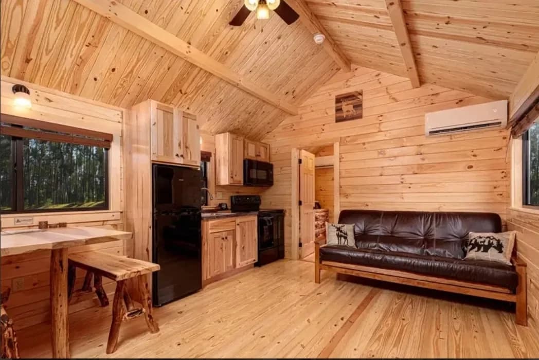 Warm pine cabin interior with a sitting area and kitchen