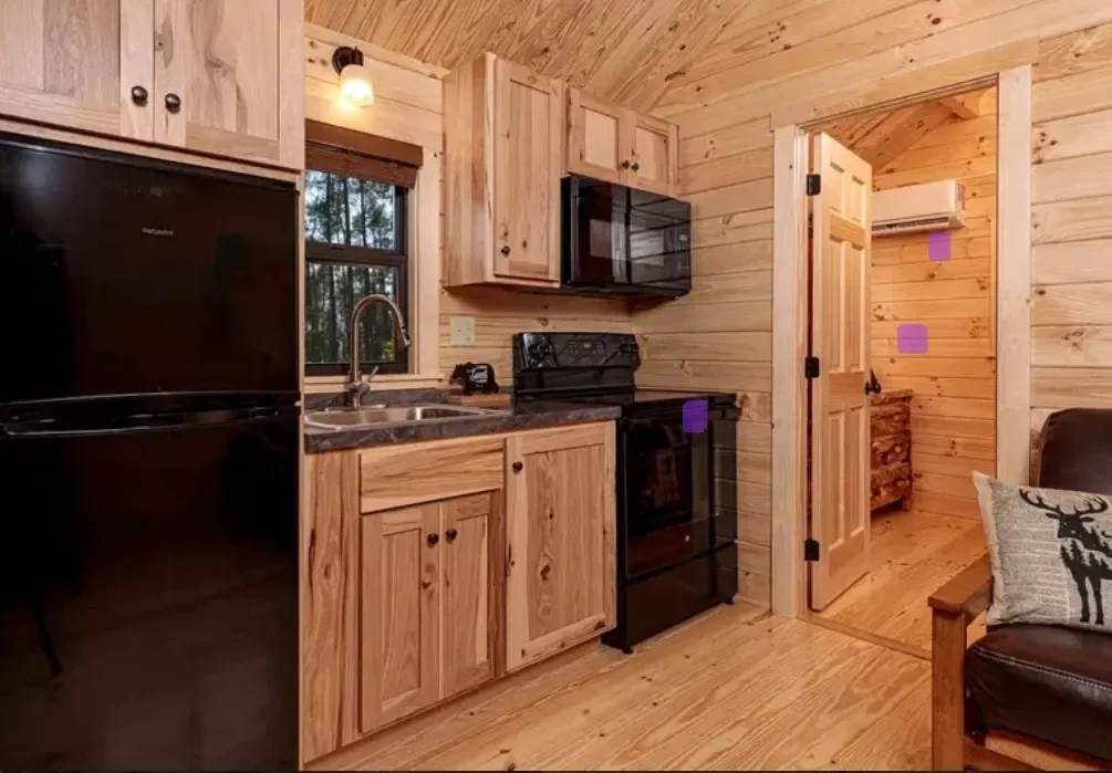 Cabin kitchen with pine cabinetry, a refrigerator, stove and microwave